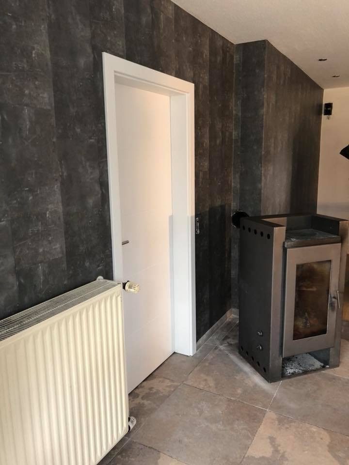 Dunkel gestaltete Wand mit Kaminofen