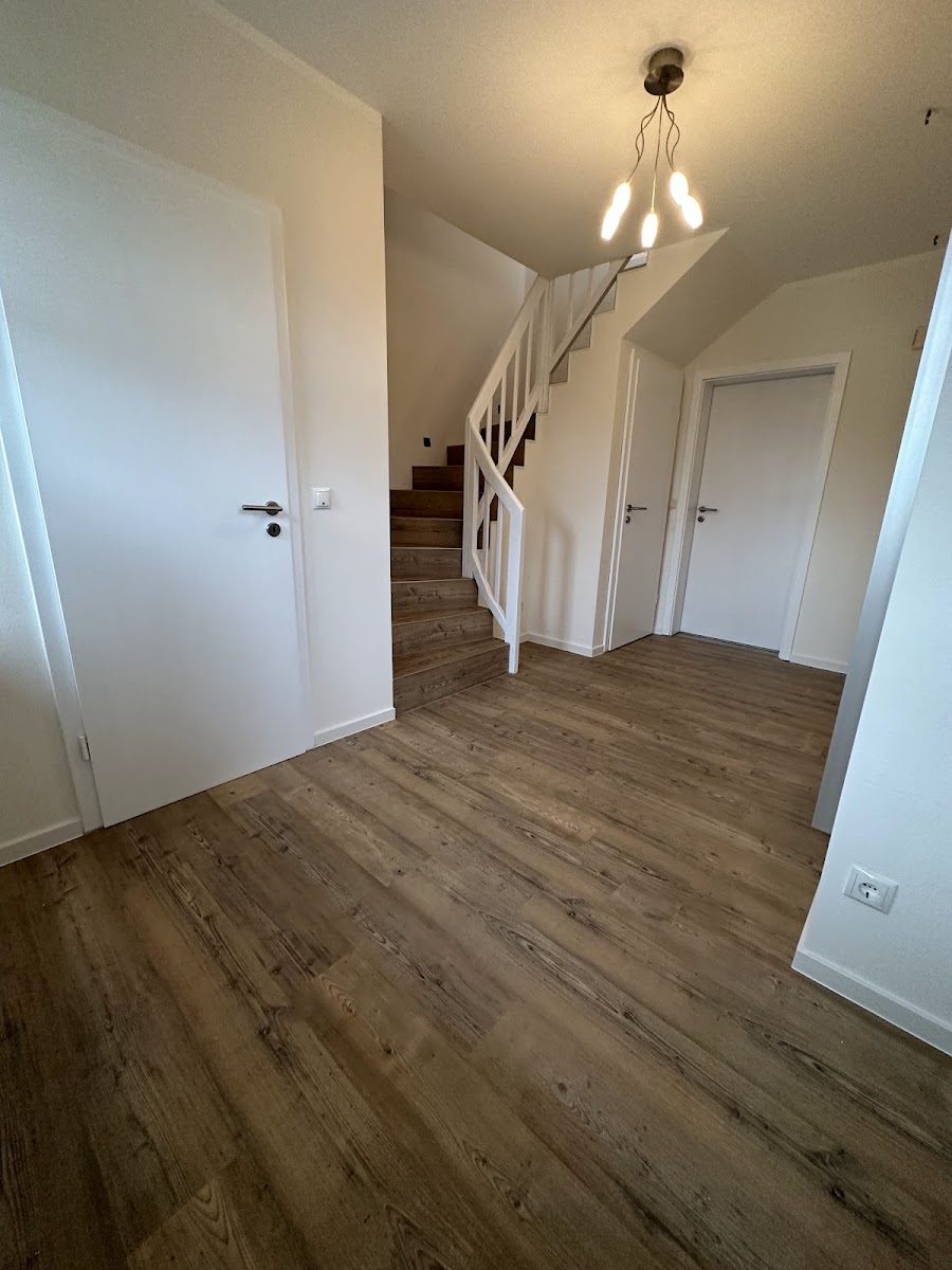 Renovierter Flur mit Treppe und Pendelleuchte in Nordhorn
