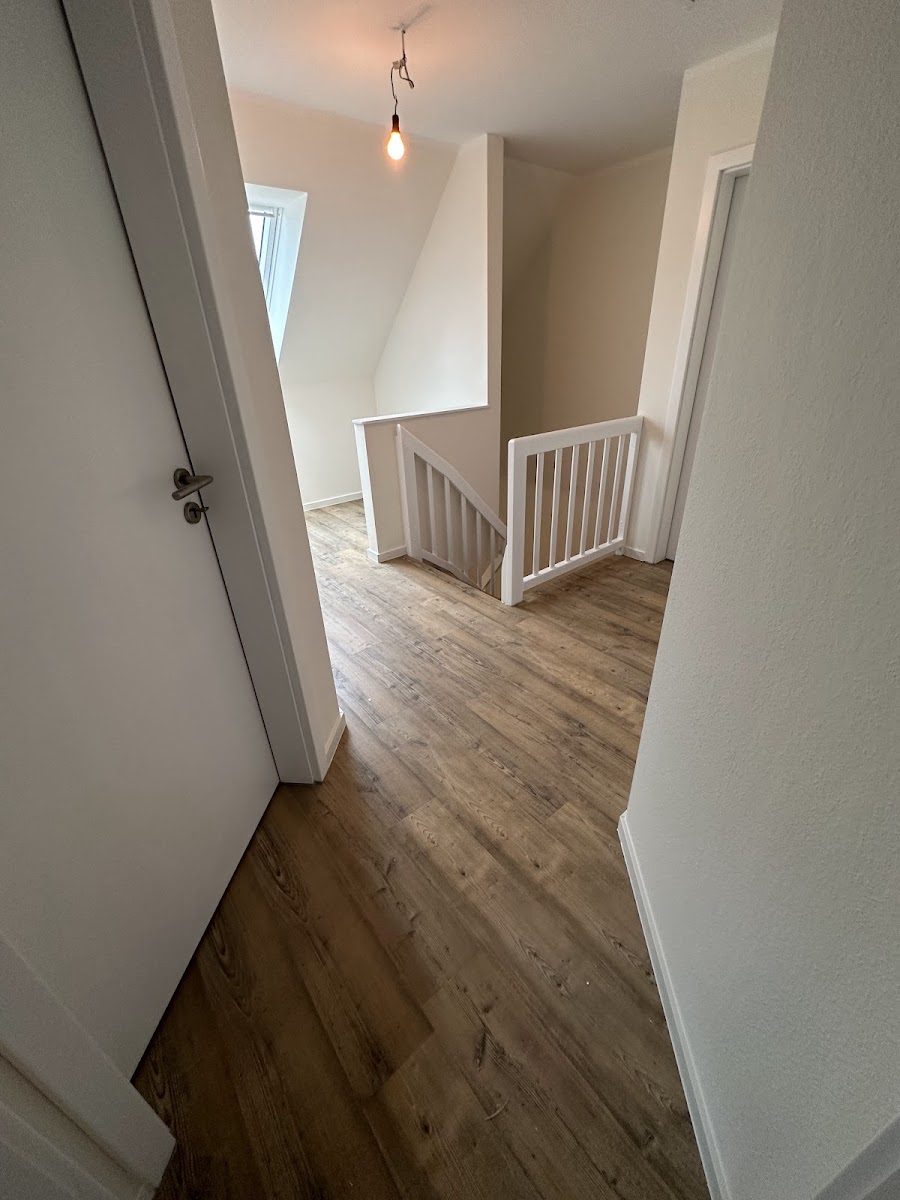Heller Flur mit weißem Treppengeländer